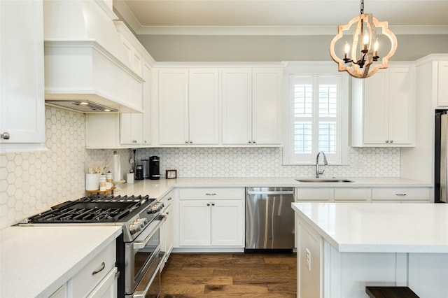12 Caravelle Ct, Galveston, TX 77554 - kitchen featuring appliances with stainless steel finishes, a sink, dark wood finished floors, a chandelier, and white cabinets