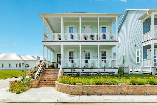 12 Caravelle Ct, Galveston, TX 77554 - view of front facade featuring covered porch, stairs, and a balcony