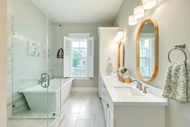 12 Caravelle Ct, Galveston, TX 77554 - full bath with double vanity, a freestanding tub, a shower with door, and baseboards