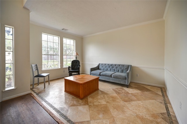 living area featuring crown molding, baseboards, and visible vents