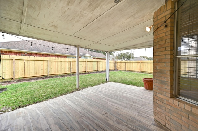 wooden deck featuring a fenced backyard and a lawn