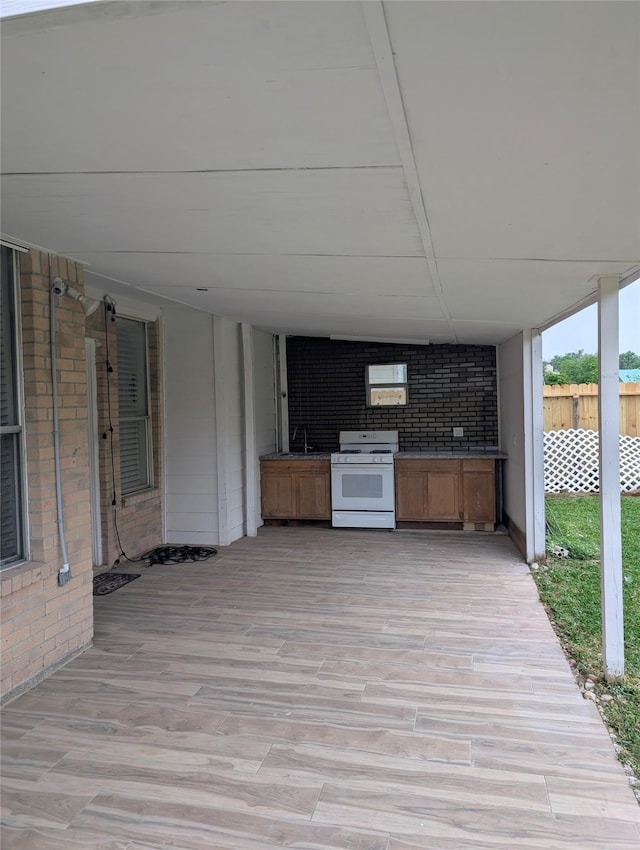 view of patio / terrace featuring fence, a sink, and exterior kitchen