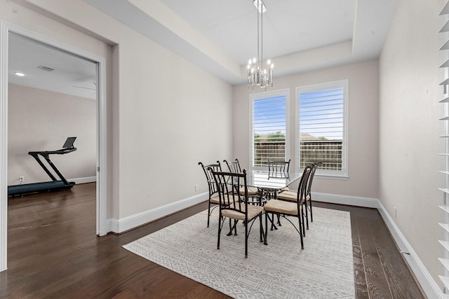 19506 Timberlake Glen Trl, Cypress, TX 77433 - dining space with dark wood-style flooring, visible vents, baseboards, a raised ceiling, and a chandelier