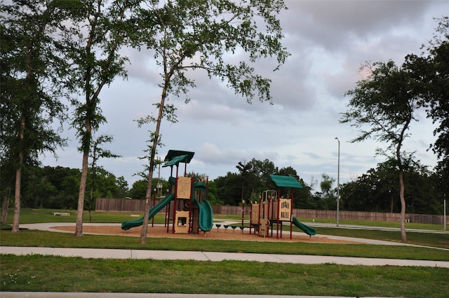 community jungle gym with fence and a yard