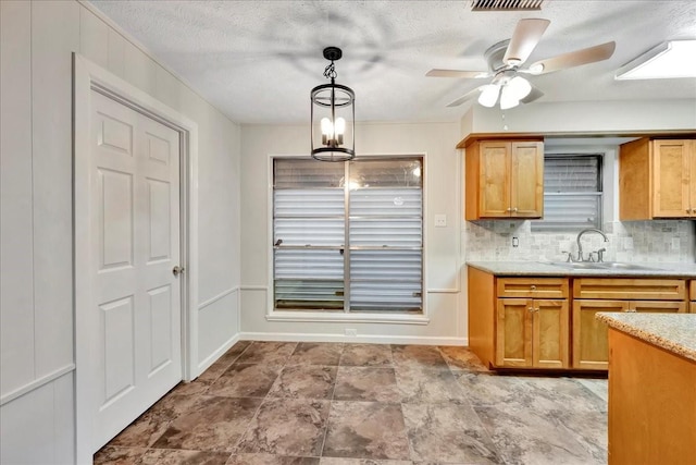 11438 Sageyork Dr, Houston, TX 77089 - kitchen with ceiling fan, a sink, a textured ceiling, backsplash, and pendant lighting