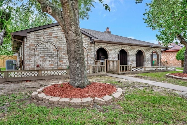 11438 Sageyork Dr, Houston, TX 77089 - view of front of property with central air condition unit, fence, a chimney, and stone siding