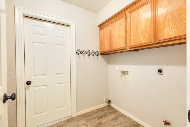 laundry area featuring light wood-style floors, baseboards, washer hookup, cabinet space, and hookup for a gas dryer