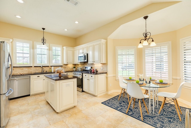 kitchen featuring visible vents, dark countertops, tasteful backsplash, a sink, and stainless steel appliances