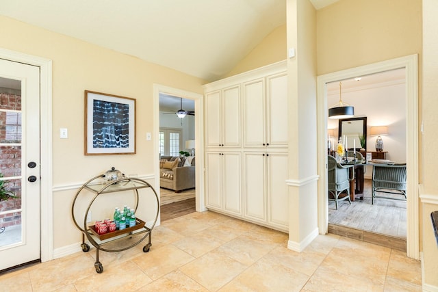 foyer with baseboards, a ceiling fan, and lofted ceiling