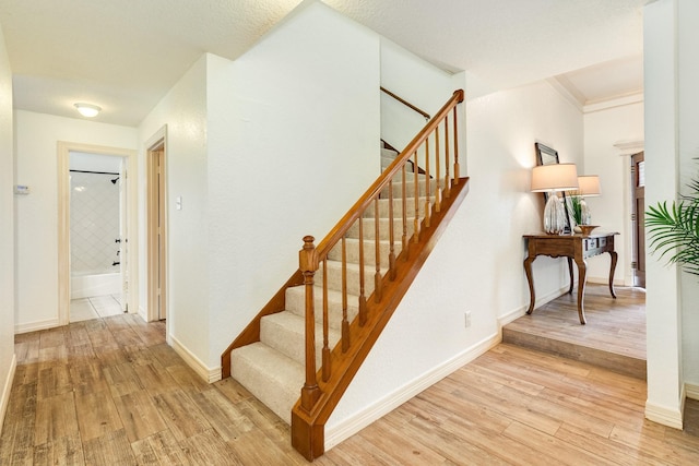 stairway with baseboards and wood finished floors