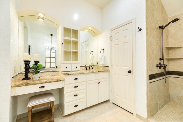 bathroom featuring vanity, decorative backsplash, and tiled shower