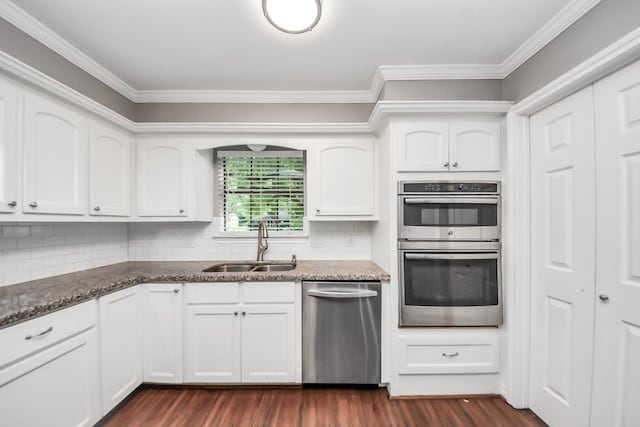 15510 Jersey Dr, Jersey Village, TX 77040 - kitchen with appliances with stainless steel finishes, ornamental molding, dark stone countertops, and dark wood-style flooring