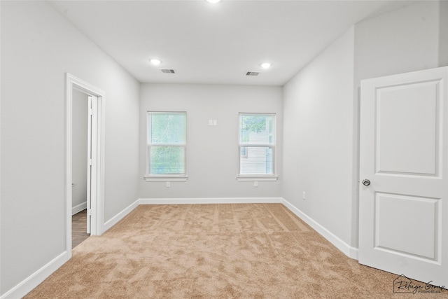 empty room featuring recessed lighting, baseboards, visible vents, and light carpet