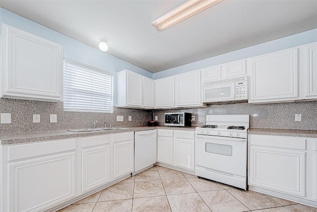 kitchen featuring a sink, tasteful backsplash, white appliances, and white cabinets