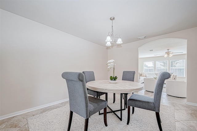 dining space featuring arched walkways, baseboards, visible vents, and ceiling fan with notable chandelier
