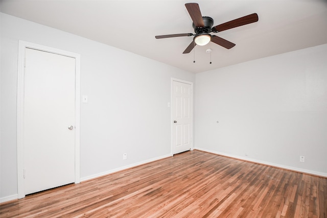 empty room featuring light wood-style flooring, baseboards, and a ceiling fan
