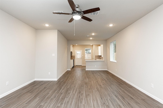 unfurnished living room featuring baseboards, a ceiling fan, wood finished floors, and recessed lighting