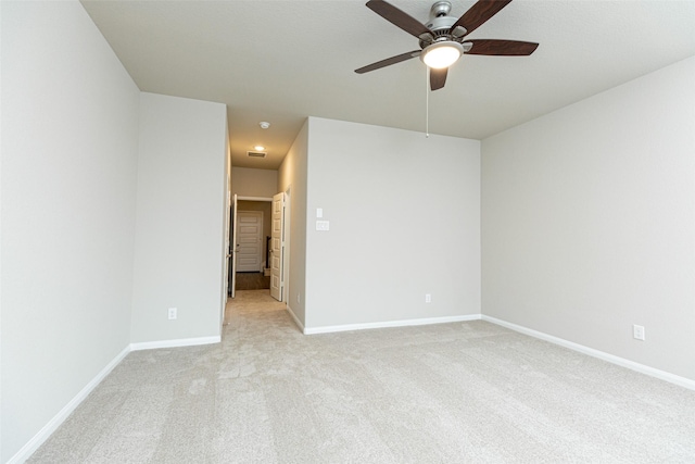 unfurnished room featuring baseboards, visible vents, a ceiling fan, and light colored carpet