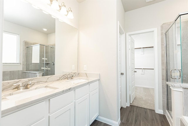 bathroom with a sink, a shower stall, and wood finished floors