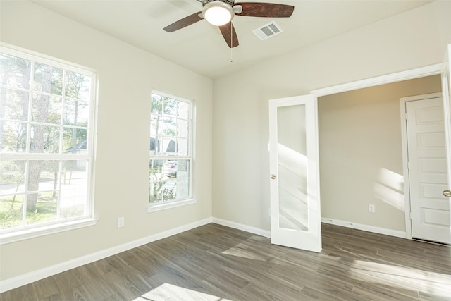 empty room with visible vents, baseboards, ceiling fan, and wood finished floors