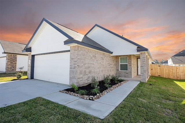 view of front of property with fence, an attached garage, brick siding, a front yard, and concrete driveway
