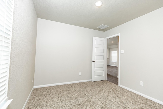 spare room with baseboards and carpet flooring