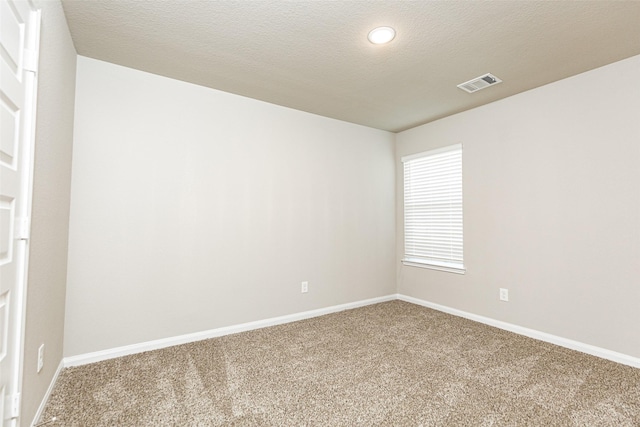 carpeted empty room featuring a textured ceiling, baseboards, visible vents, and recessed lighting