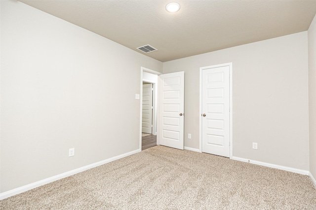 unfurnished bedroom featuring baseboards, carpet, recessed lighting, and visible vents