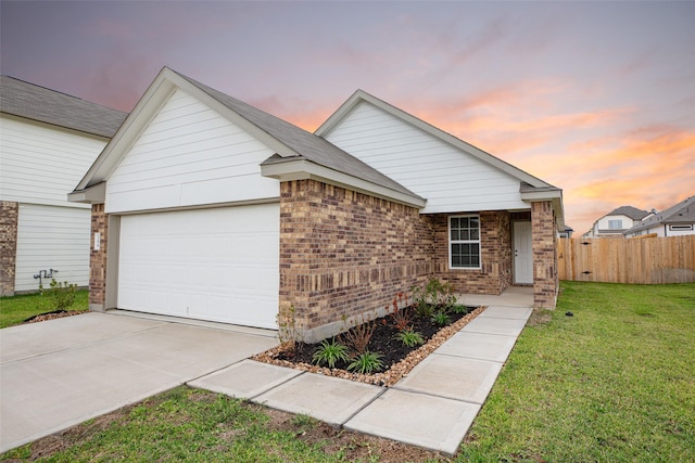 ranch-style home featuring a yard, brick siding, fence, concrete driveway, and an attached garage