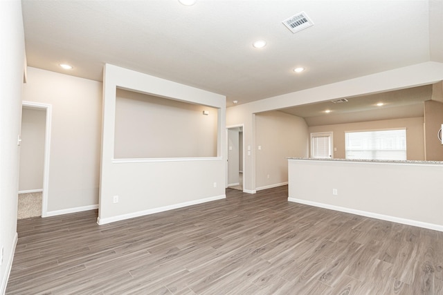 empty room with baseboards, recessed lighting, wood finished floors, and visible vents