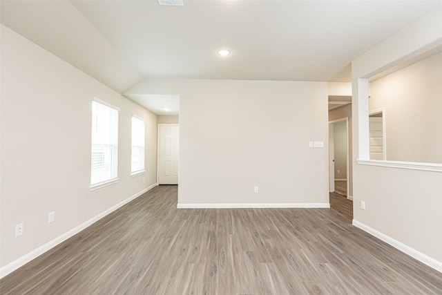 spare room featuring recessed lighting, baseboards, and wood finished floors