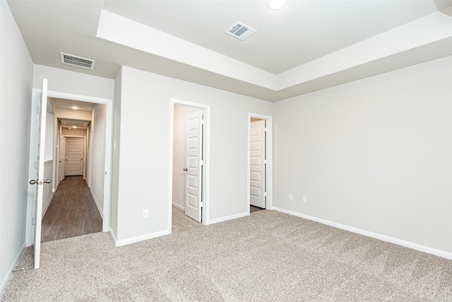 unfurnished bedroom featuring baseboards, visible vents, a walk in closet, and carpet