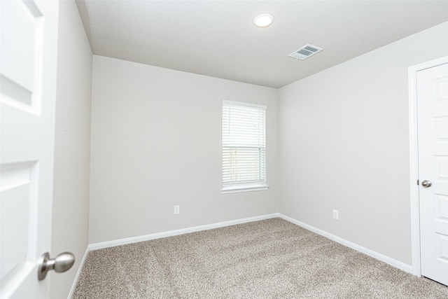 empty room with baseboards, carpet flooring, and visible vents
