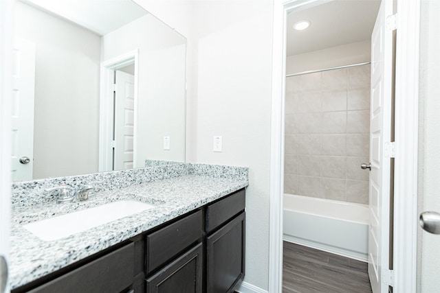 bathroom with recessed lighting, bathtub / shower combination, wood finished floors, and vanity