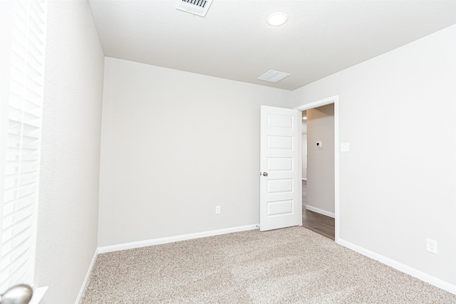carpeted empty room with baseboards and visible vents