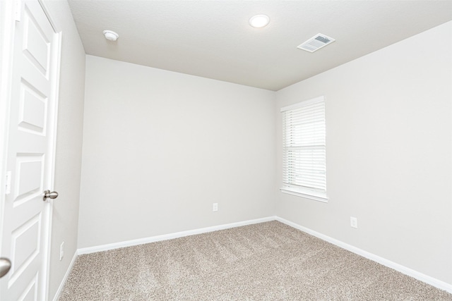 carpeted empty room with visible vents and baseboards