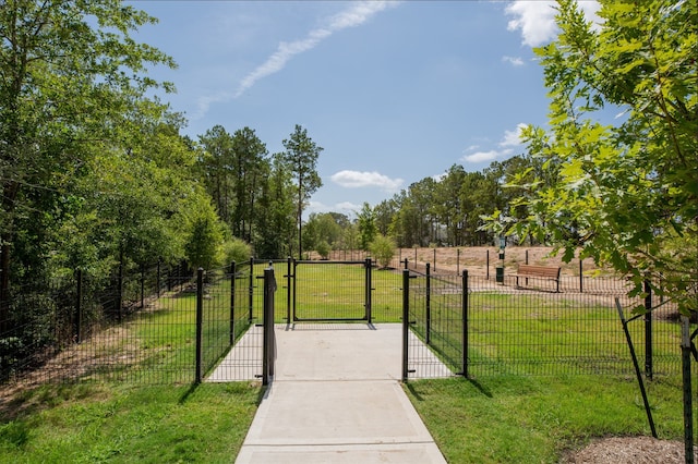 view of property's community with fence, a gate, and a yard