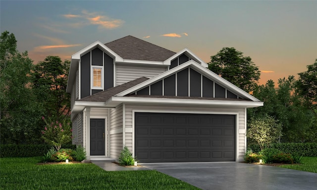 traditional-style home with an attached garage, a shingled roof, concrete driveway, and a front yard