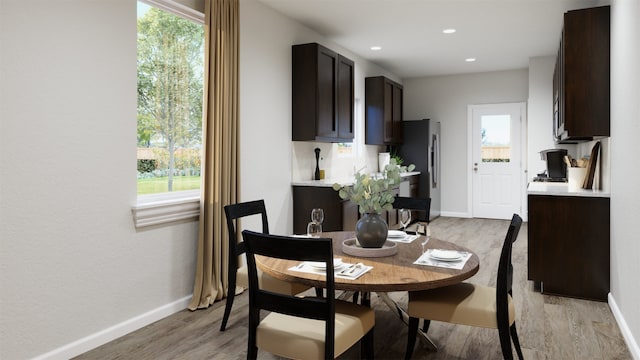 dining room featuring baseboards, a wealth of natural light, and light wood-style flooring