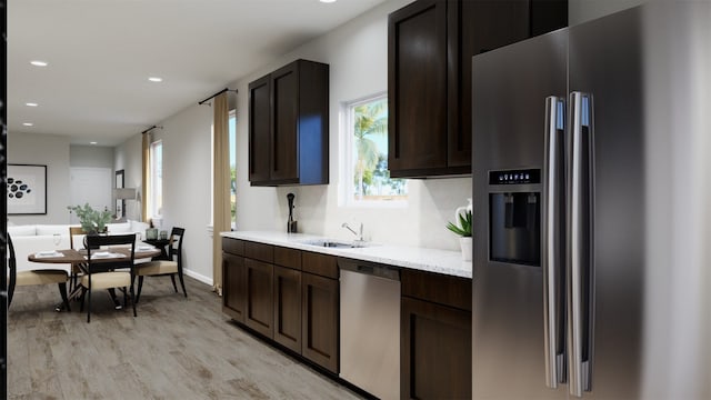 kitchen featuring dark brown cabinetry, light wood-type flooring, recessed lighting, a sink, and stainless steel appliances