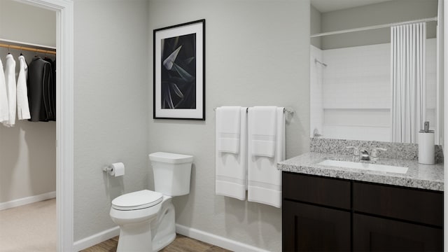 full bath featuring vanity, baseboards, a shower, and toilet