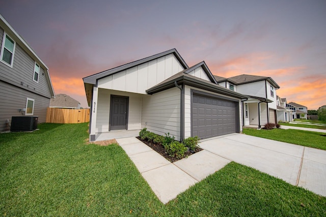 5114 Hector Gustavo Dr, Rosharon, TX 77583 - view of front facade with a yard, board and batten siding, driveway, cooling unit, and an attached garage