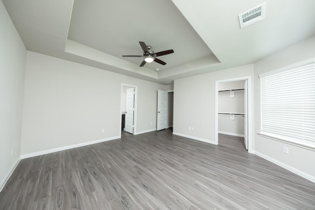 5114 Hector Gustavo Dr, Rosharon, TX 77583 - unfurnished bedroom with baseboards, visible vents, wood finished floors, and a raised ceiling
