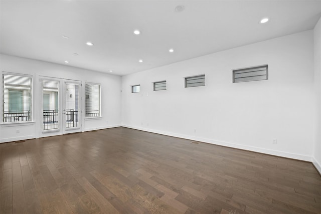 spare room with baseboards, recessed lighting, and dark wood-type flooring