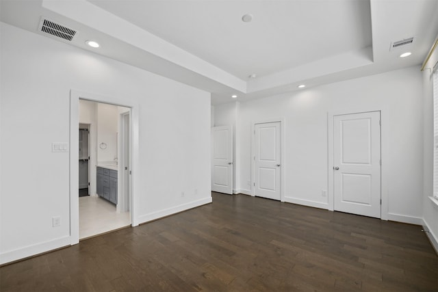 unfurnished bedroom featuring recessed lighting, a raised ceiling, and visible vents
