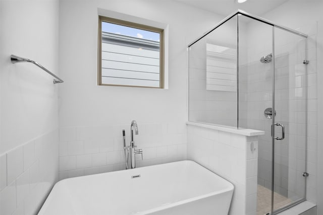 full bath with a freestanding bath, a sink, and a stall shower