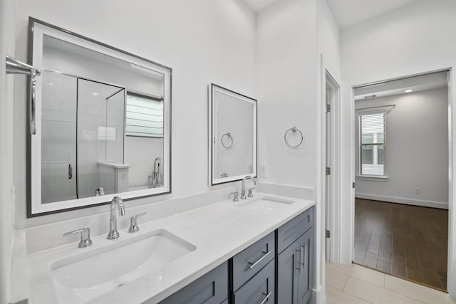 bathroom with double vanity, tile patterned floors, a shower stall, and a sink