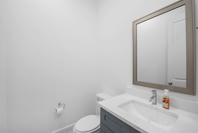 bathroom featuring vanity, baseboards, and toilet
