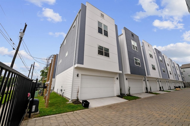 exterior space featuring an attached garage, fence, and driveway