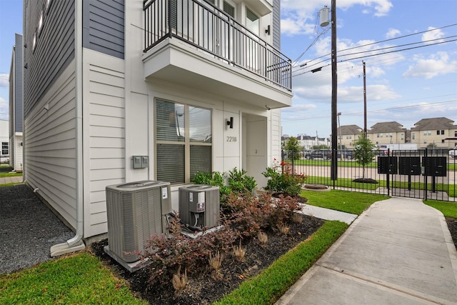 exterior space with fence, a residential view, cooling unit, and a balcony